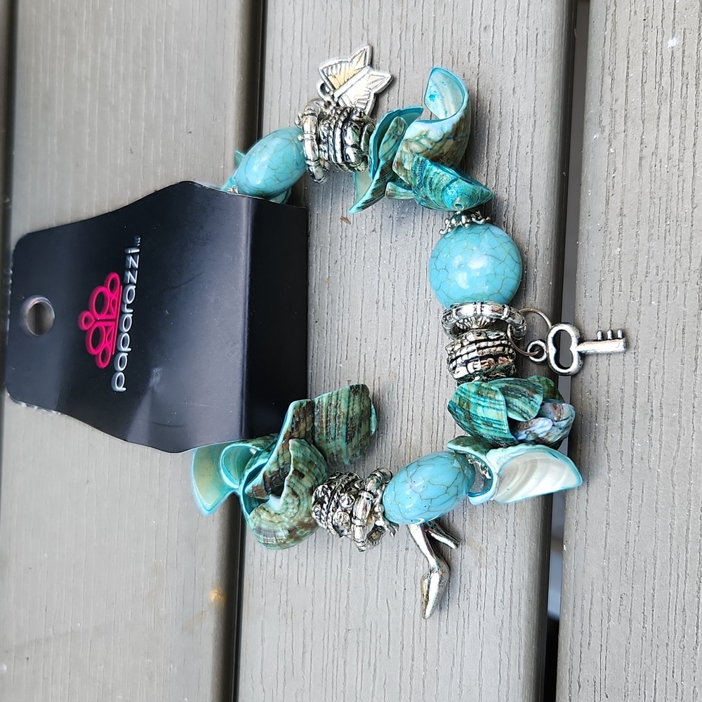 Dark Shades of Aqua Colored Shells and Silver Charms Stretch Bracelet.